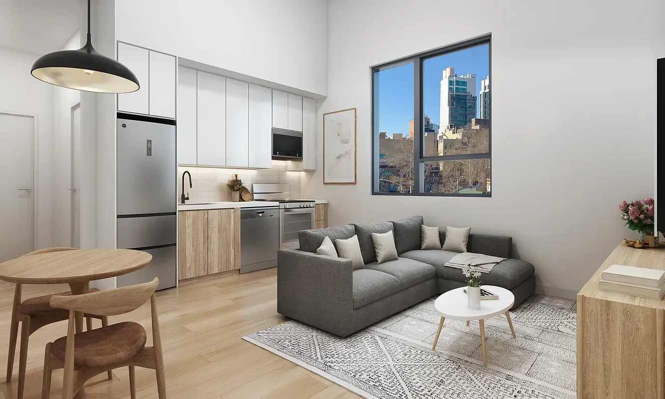 Open-plan living area with kitchen, dining table, gray sofa, pendant light, and city views through windows.